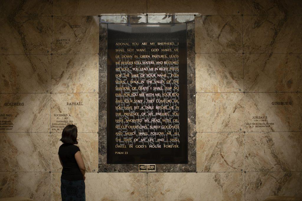 Woman looking at the Twenty-third Psalm artwork at the Beth El Mausoleum